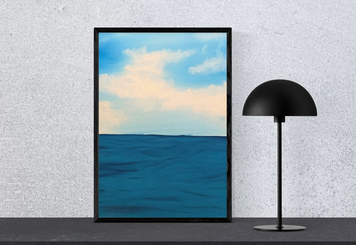 Original blue seascape painting displayed beside a black lamp